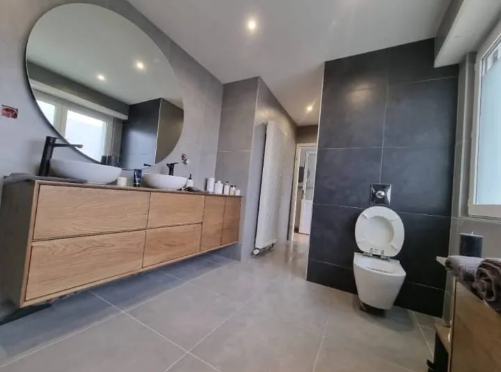 Çift lavabolu ahşap dolap ve asma klozetli banyo